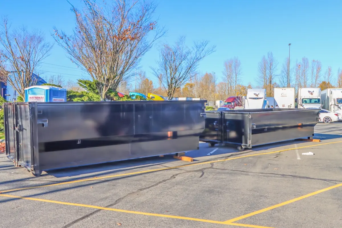Professional dumpster rental service with roll-off container on residential driveway in Tarrant